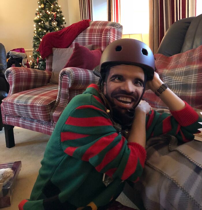 Person with helmet and mask in a festive living room, embodying hilarious in-laws humor.