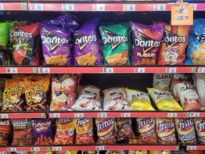 Variety of colorful snack bags on a store shelf, highlighting deceptive-marketing-techniques.