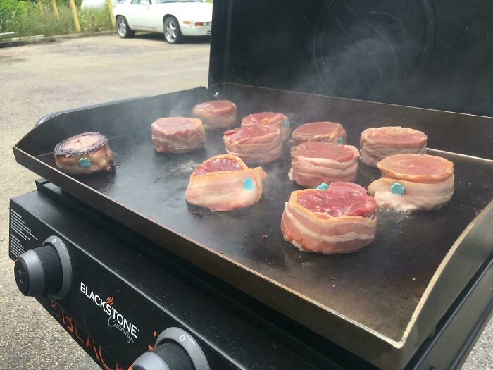 Grill with steaks wrapped in bacon, a humorous meal by good-funny-bosses, cooking outdoors.