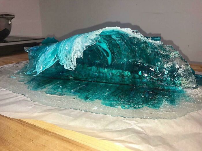 Edible sugar sculpture resembling a blue ocean wave, showcasing beautiful food artistry.