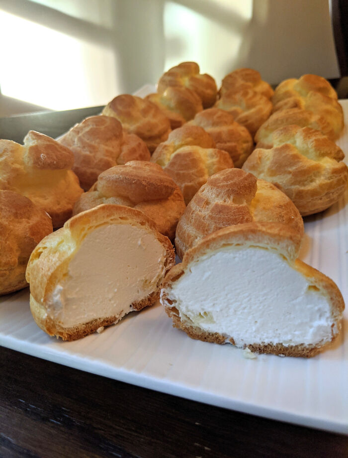 Delicious cream puffs on a white plate, perfect for foodies to love and savor.