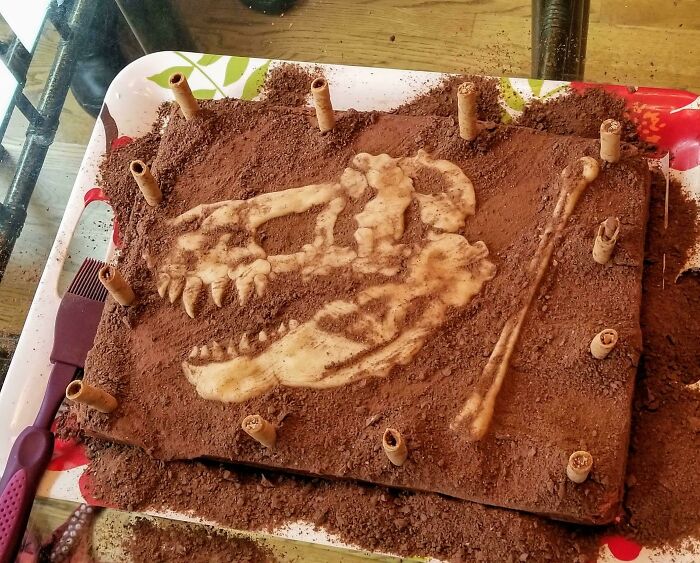 A chocolate cake featuring a dinosaur fossil design, appealing to foodies with its creative and beautiful presentation.