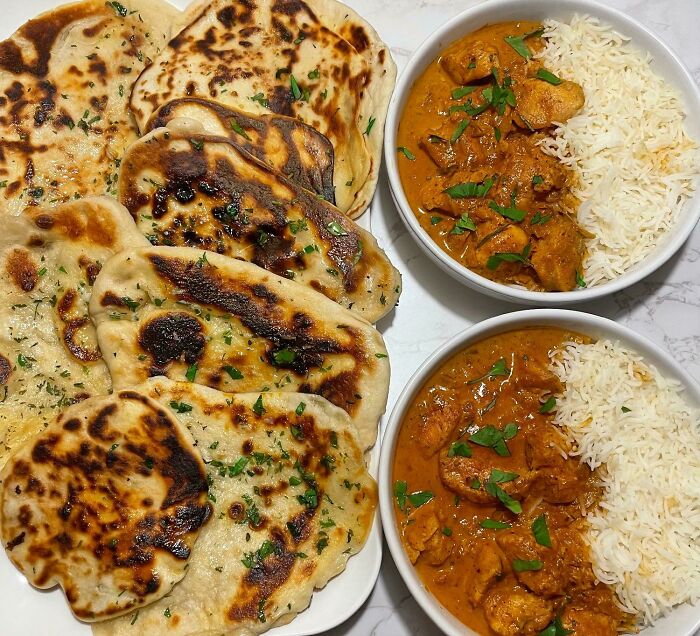 Delicious food for foodies: naan bread alongside flavorful curry and rice bowls, garnished with fresh herbs.