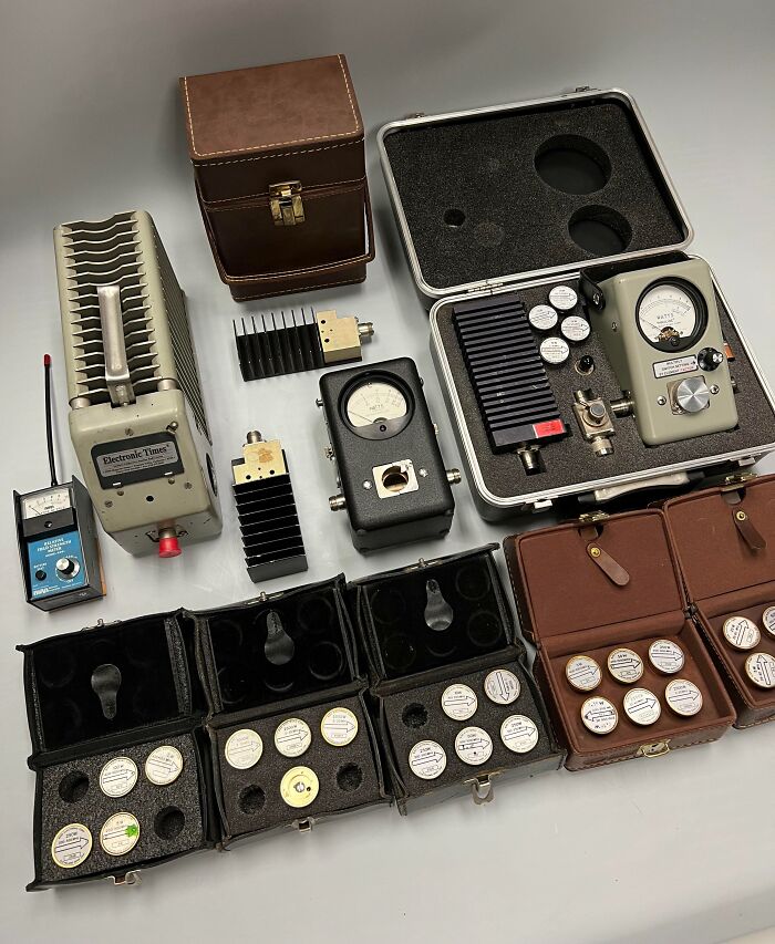 Vintage electronic devices and cases inherited, featuring gauges and dials, showcasing unique collectibles.