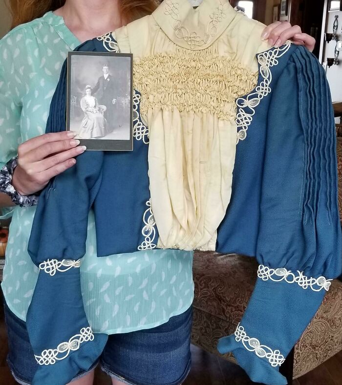 Woman holding vintage dress and old photo, showcasing coolest inheritance.