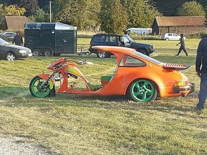 Orange car frame fused with motorcycle, showcasing a unique car-fails creation on a grassy field.