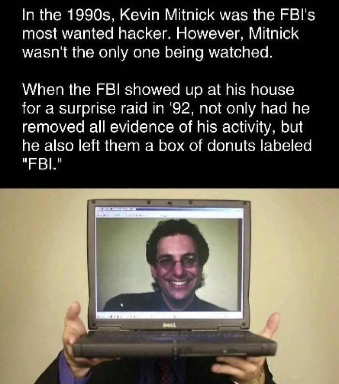 Man holding a laptop showing a smiling image, with curiosity about FBI's most wanted hacker in the 1990s.