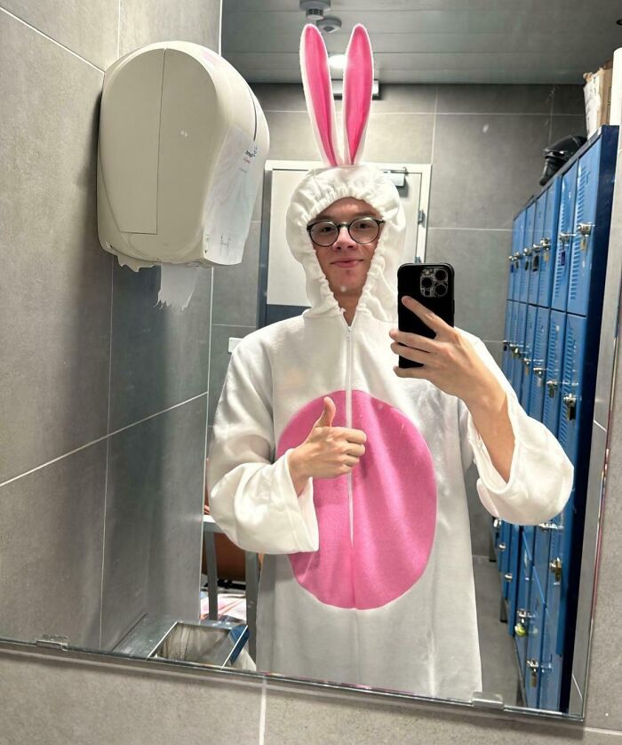 Person in a funny bunny costume taking a mirror selfie, showcasing good humor in a workplace setting.