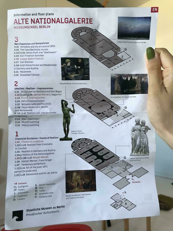 Museum visitor holding a floor plan of Alte Nationalgalerie, showcasing Neo-Classicism, Romanticism, and Impressionism sections.