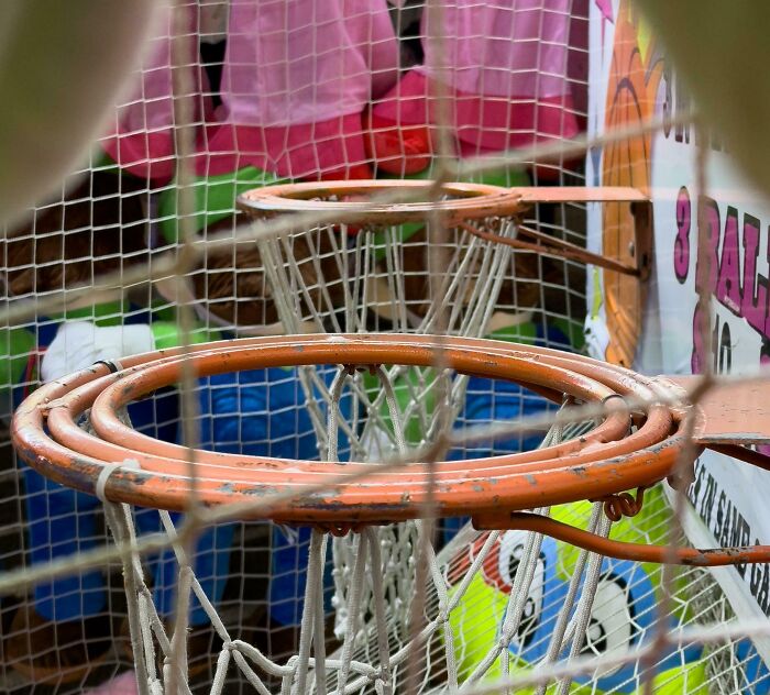 Carnival hoop game with multiple basketball hoops, illustrating deceptive-marketing-techniques.