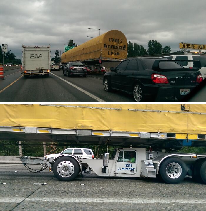 Oversize load on highway, interesting sight with large covered equipment on a truck, flanked by regular traffic.