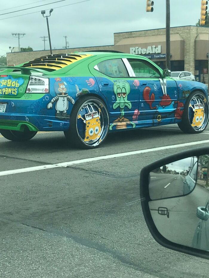 Colorful car decorated with cartoon characters spotted on the road.