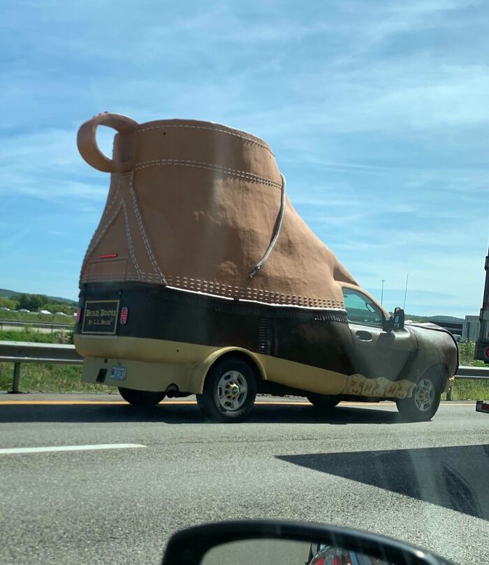 Novelty shoe-shaped vehicle driving on the highway, showcasing interesting things on the road.