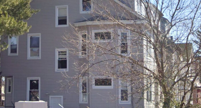 Atrocious house with mismatched windows, proving money can’t buy taste, shown in a cluttered architectural style.