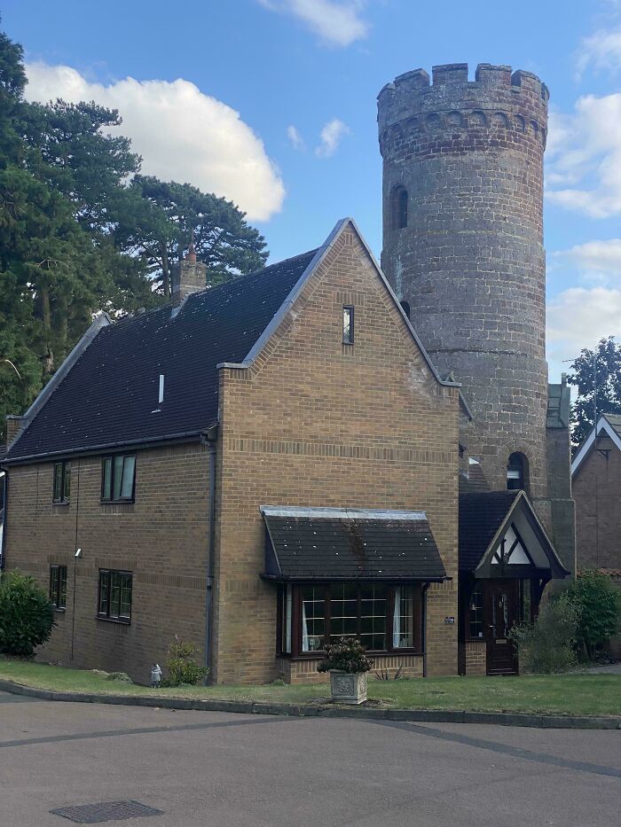 House with mismatched architecture featuring a modern brick facade and an attached medieval-style stone tower.