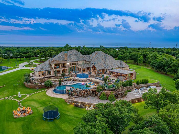 Luxurious mansion with pool and expansive greenery, illustrating that money can’t buy taste.