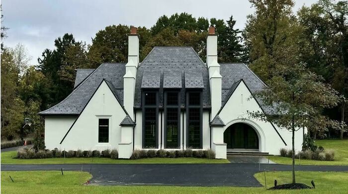 Unusual house design with steep gabled roof and tall chimneys, illustrating that money can't buy taste.