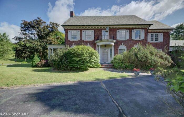 Brick house with lush bushes in front, illustrating that money can't buy taste.