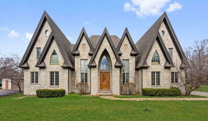 Unusual house with sharp, peaked roofs, showcasing that money can't buy taste in architecture design.