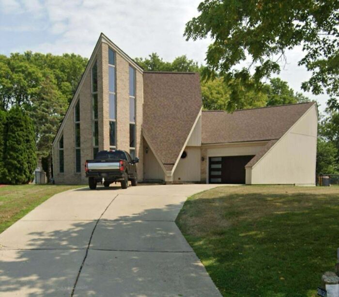 Unique modern house with geometric design and large windows, challenging conventional taste in architecture.