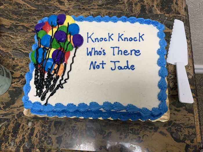 Cake with humorous message "Knock Knock Who's There Not Jade," featuring colorful balloon decorations.