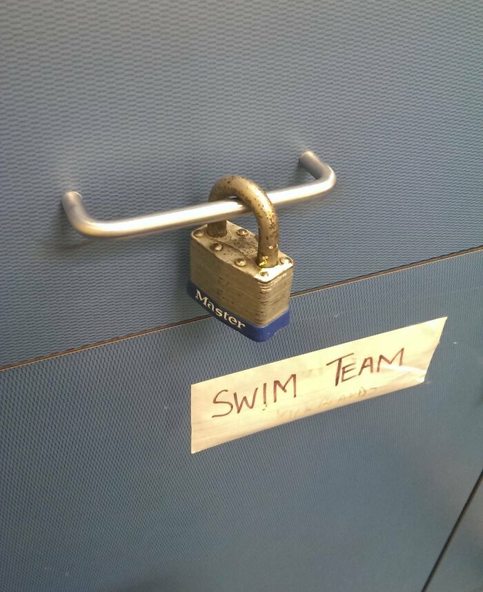 Steel cabinet with a padlock, labeled "Swim Team," in a humorous workplace setting related to good-funny-bosses.