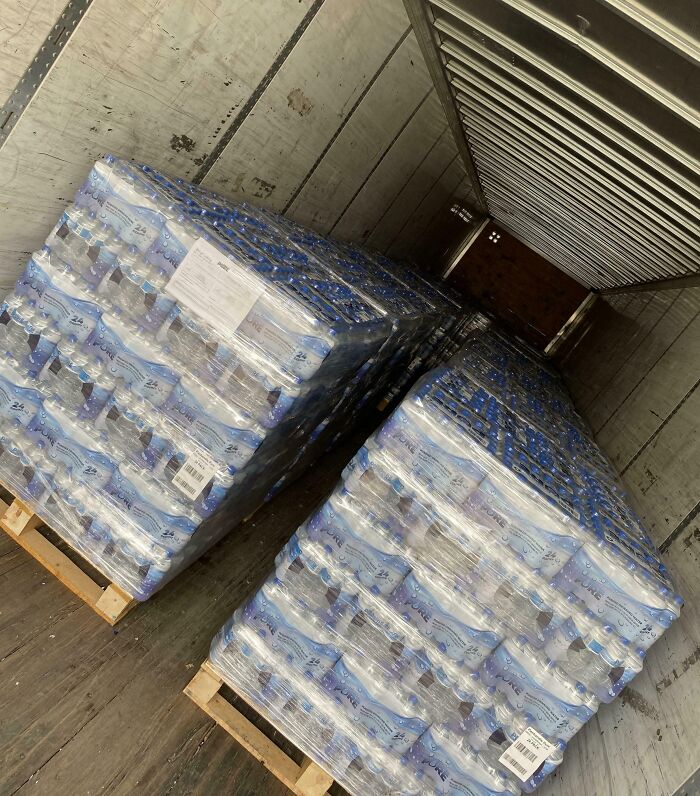 Pallets of bottled water stacked inside a large truck, showcasing good-funny-bosses logistics humor.