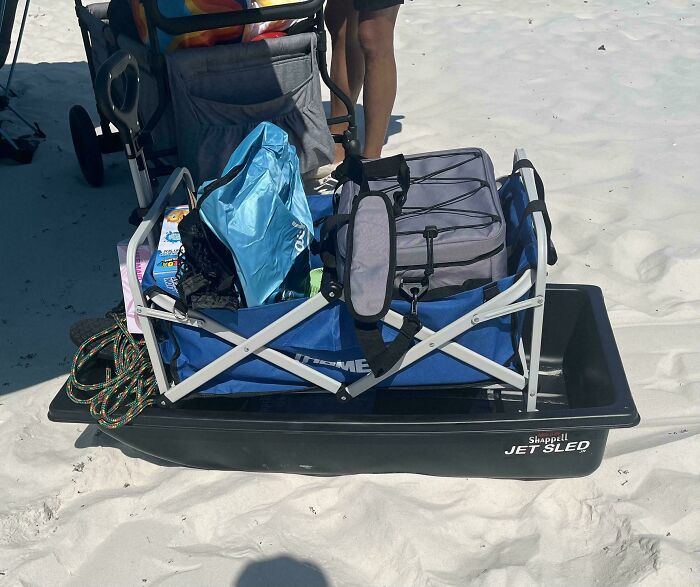 A beach cart loaded with gear and a Jet Sled showcasing parenting genius tricks for easy transport on sand.