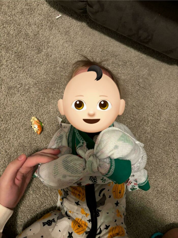 Baby swaddled in a blanket, showcasing a parenting trick on a textured carpet.