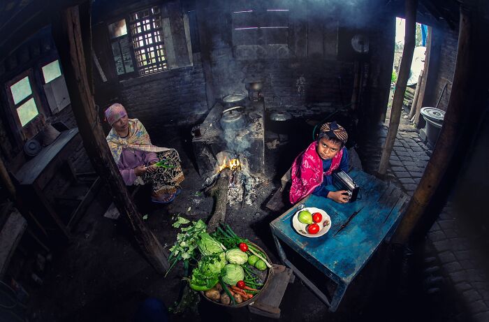 Traditional kitchen scene with people and vegetables, showcasing captivating photographs.