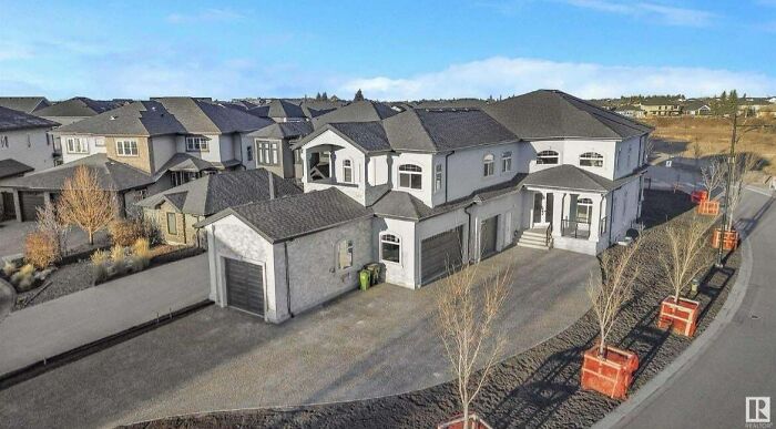 Luxury house with irregular design showing that money can't buy taste, featuring mismatched architecture and barren landscaping.