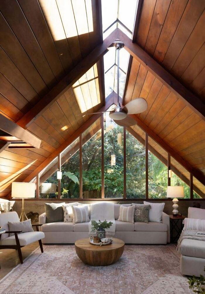 Luxury living room with wooden ceiling and large windows, showing that money can't buy taste.