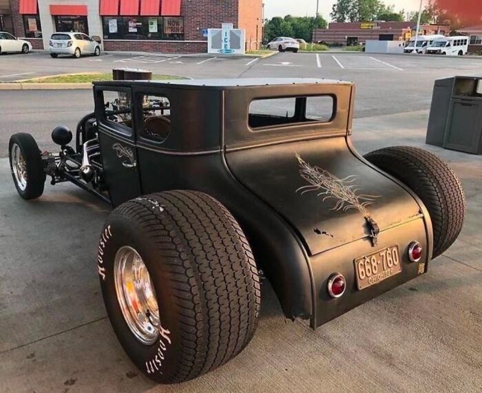 Custom-built car with oversized tires in a parking lot, highlighting car-fails design features.