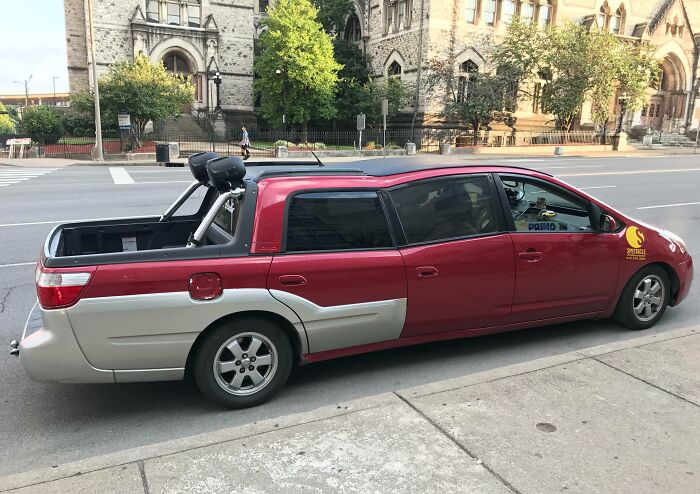 Unusual car modification with truck bed attachment, showcasing car-fails concept in an urban setting.