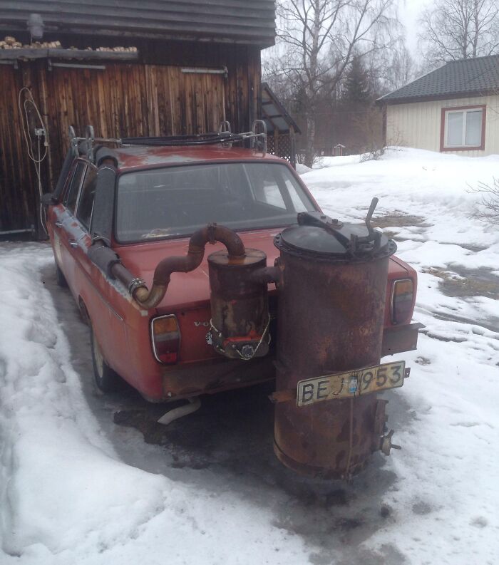 Old car with a unique DIY exhaust system, parked in snowy surroundings, showcasing a classic car-fail moment.