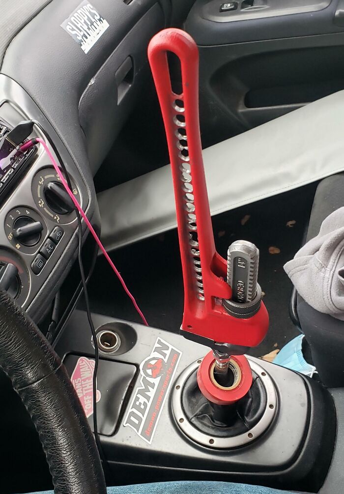 DIY gear shift hack with large red wrench in a car’s interior, showcasing a unique Car-Fails moment.