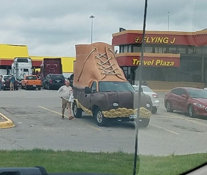 Car-Fails: A vehicle designed to look like a giant boot parked at a travel plaza.