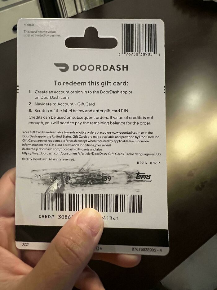 Person holding a scratched DoorDash gift card, symbolizing Christmas mishap.