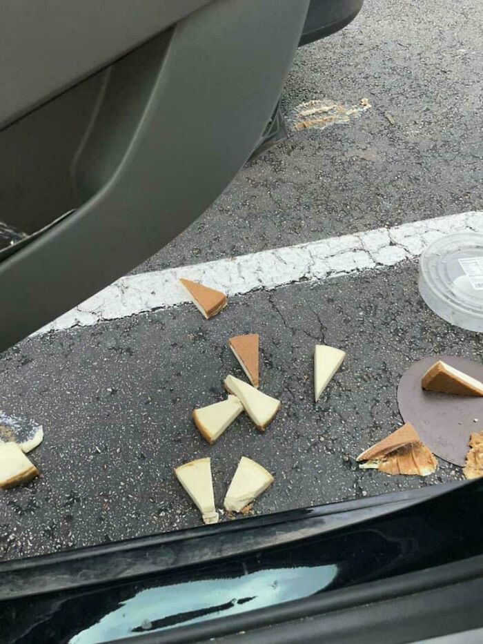 Sliced cheesecake on the ground by car door, a Christmas accident.