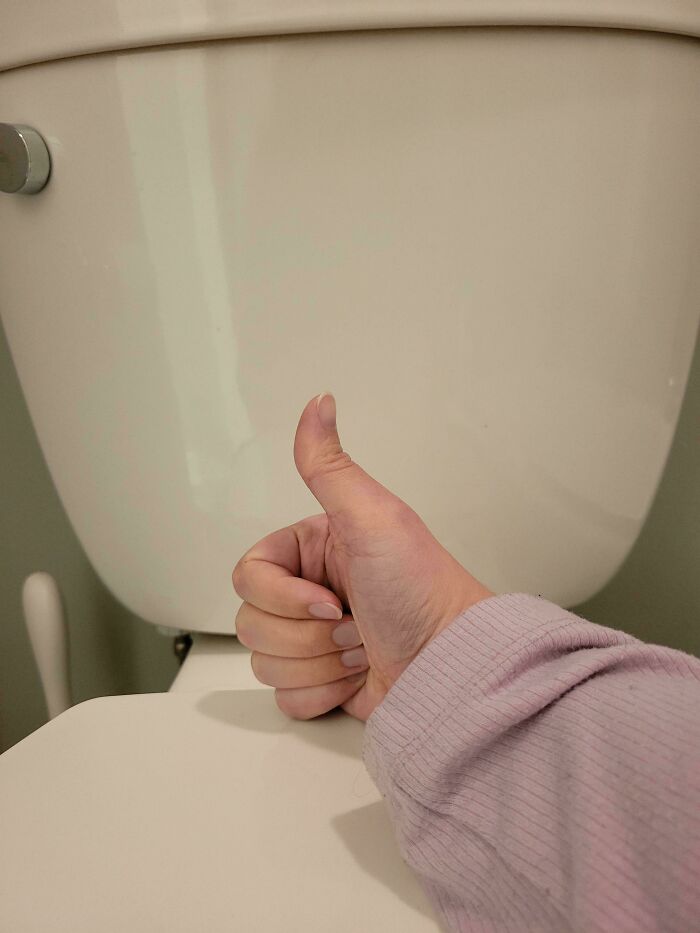 Thumbs up in front of a toilet, possibly signifying a Christmas accident resolution.