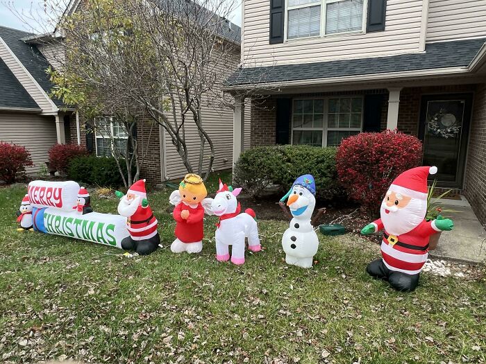 Inflatable Christmas decorations blown over in front yard.