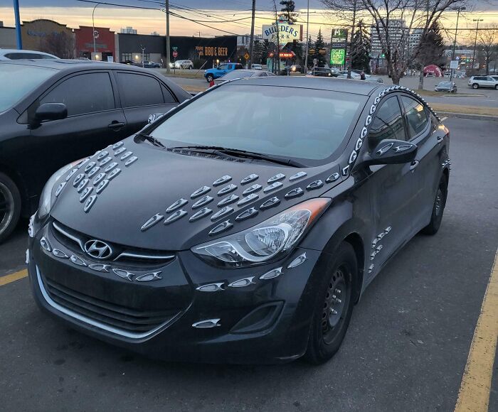 Unusual Hyundai with extra badges, illustrating a classic car-fail in a parking lot.