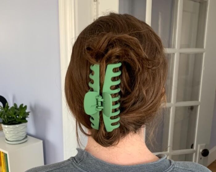 Teen with a green hair clip in a casual setting.