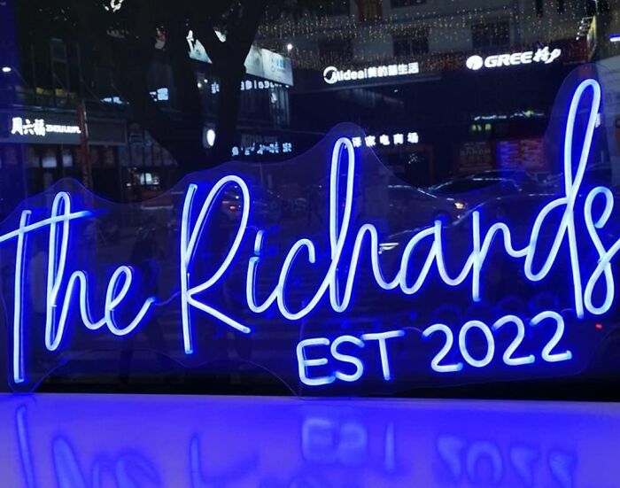 Neon sign displaying "The Richards EST 2022" in a city setting, ideal gifts for teens.