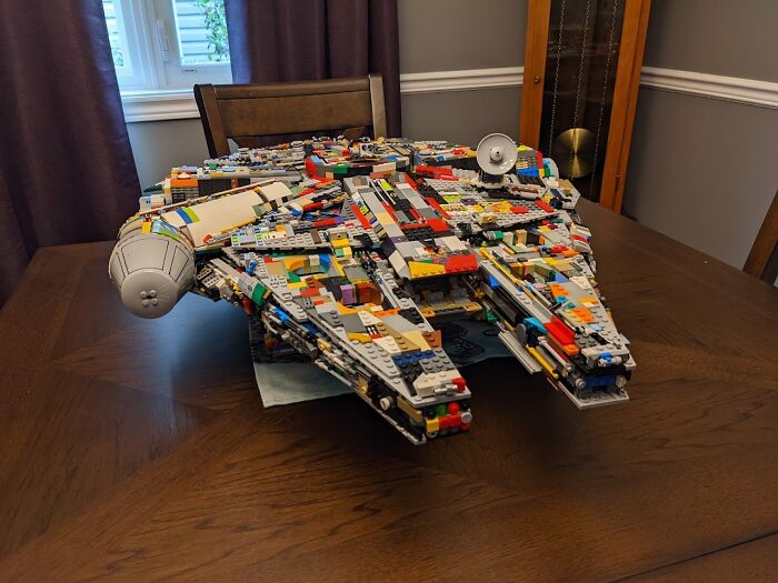 LEGO model of a spaceship on a wooden table under soft lighting, showcasing fascinating detail.