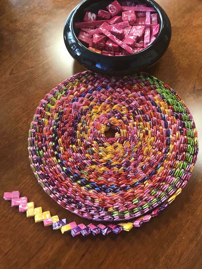 Creative starburst paper chain crafted from colorful candy wrappers on a table.