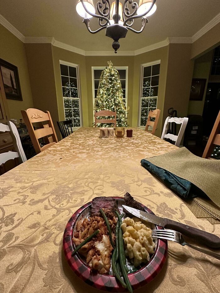 Festive dining table with Christmas tree in background and dropped food on a plate, symbolizing holiday accidents.