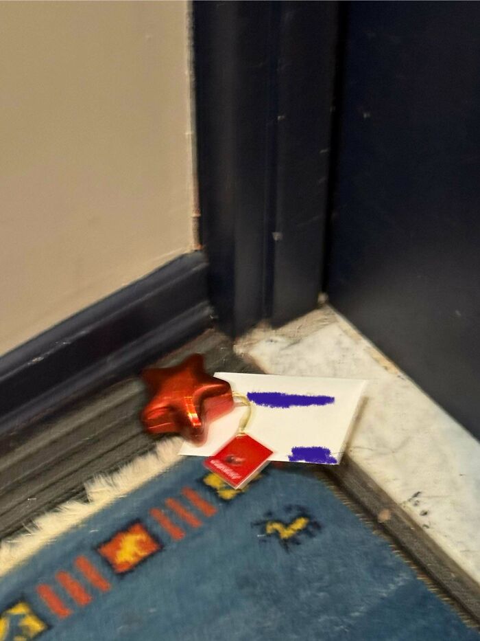 Christmas accident with a dropped ornament and card on the floor near a door, highlighting a festive mishap.