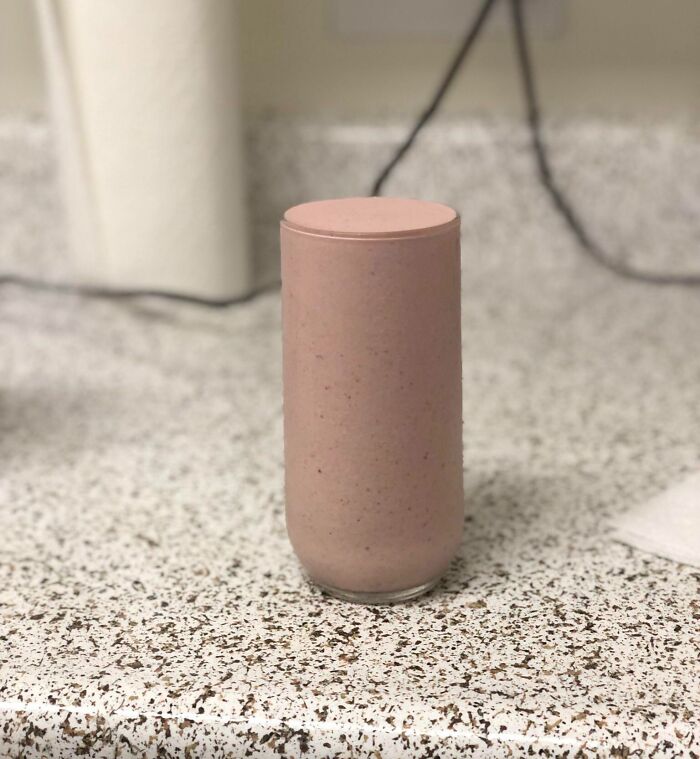 A smoothie perfectly fills a glass on a speckled countertop, showcasing a satisfying perfect fit.