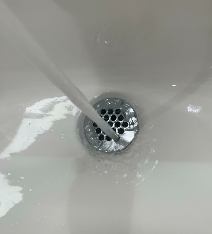 Water flowing perfectly into a sink drain, creating a satisfying perfect fit.